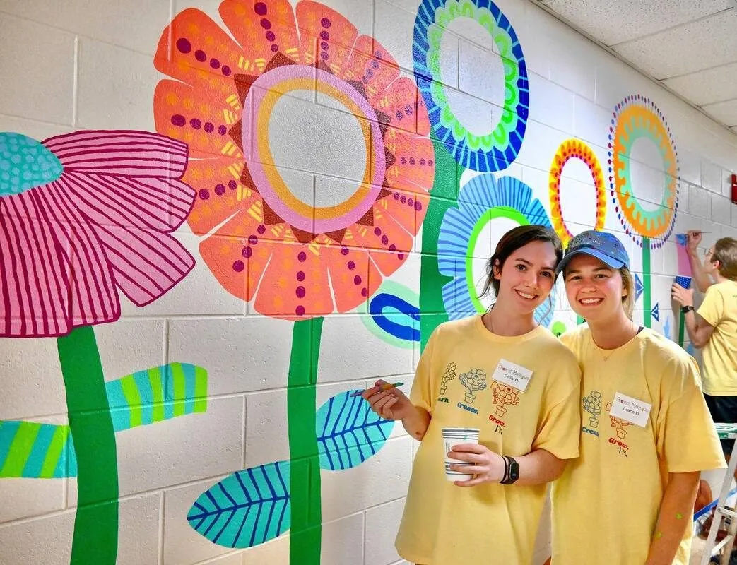 A wall of large stylised flowers painted in bright colours