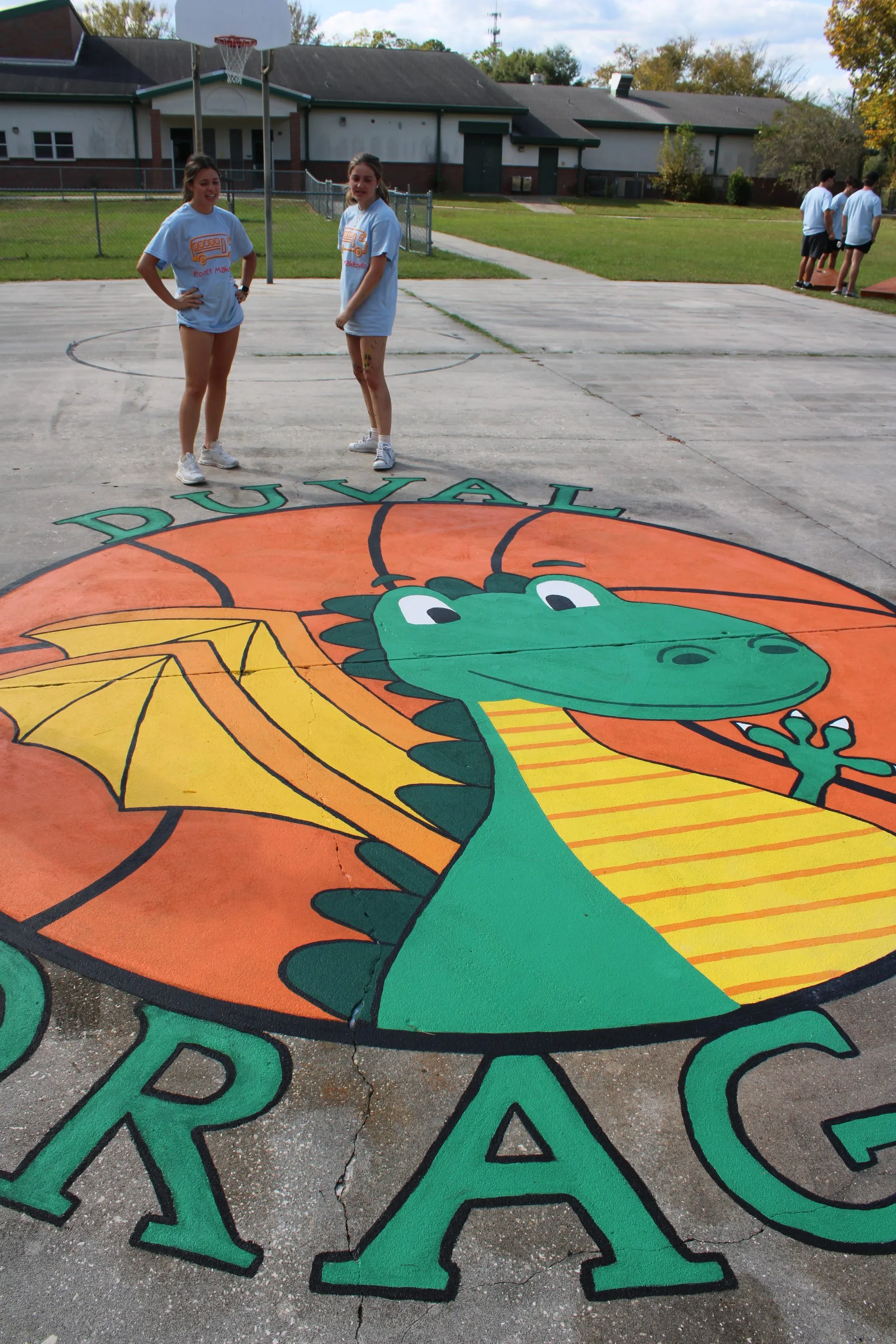A dragon roundel painted on a school playground, lettered Duval Dragons