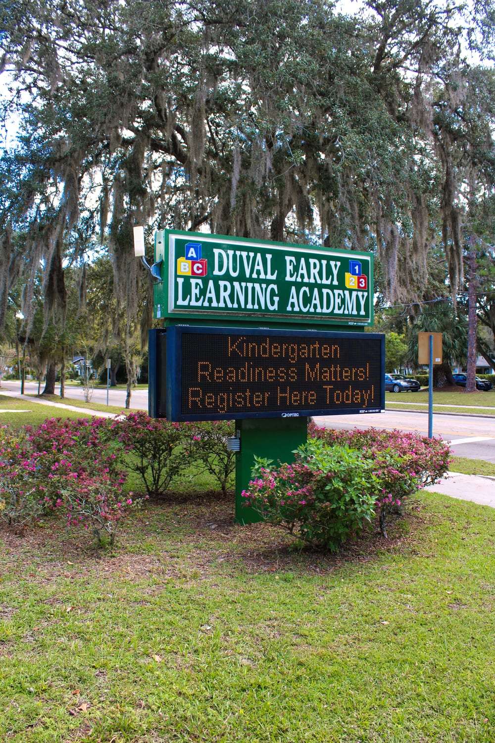 The Duval Early Learning Academy sign beneath a canopy of oak trees