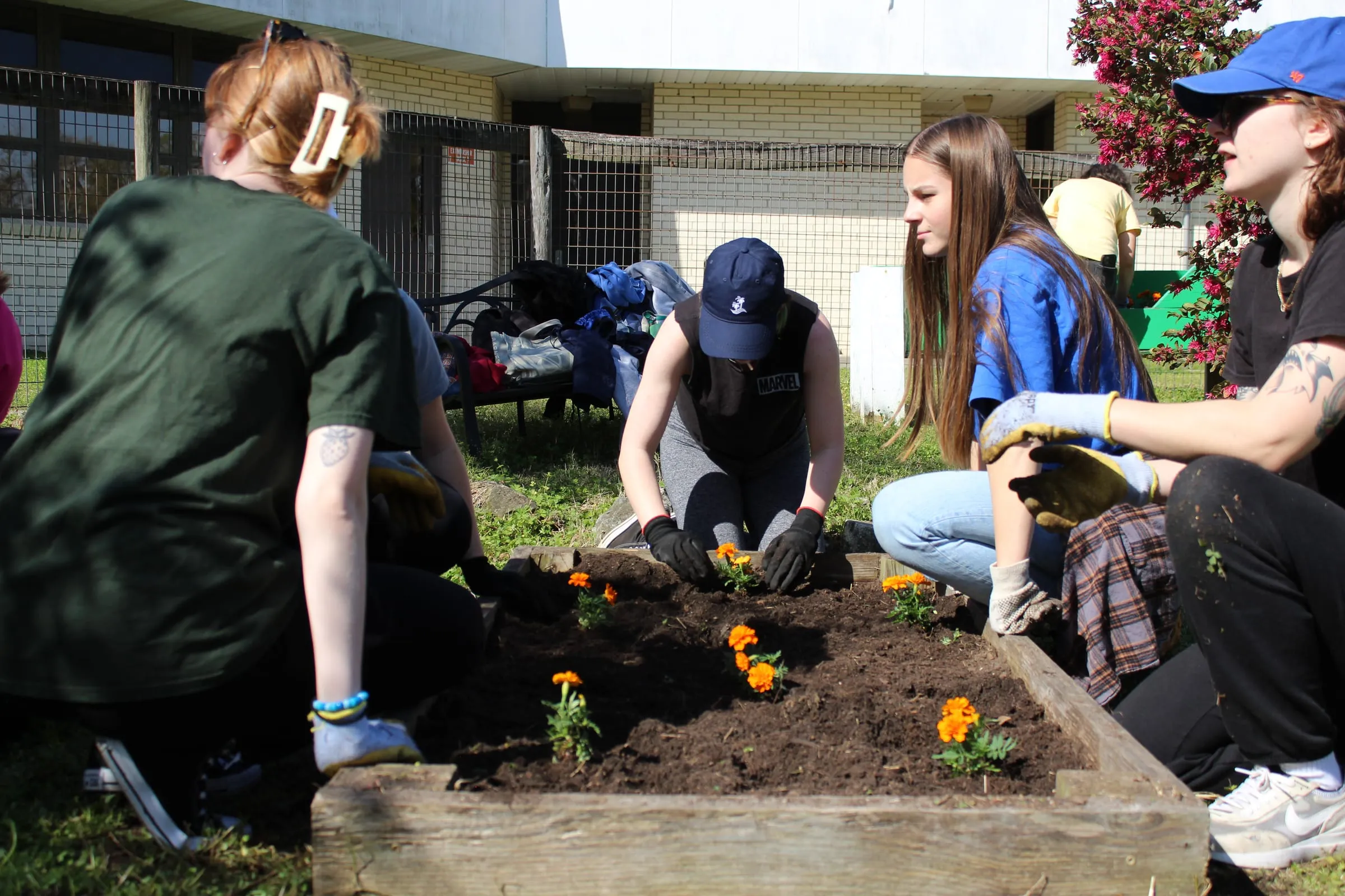 Volunteers planting a raised garden bed