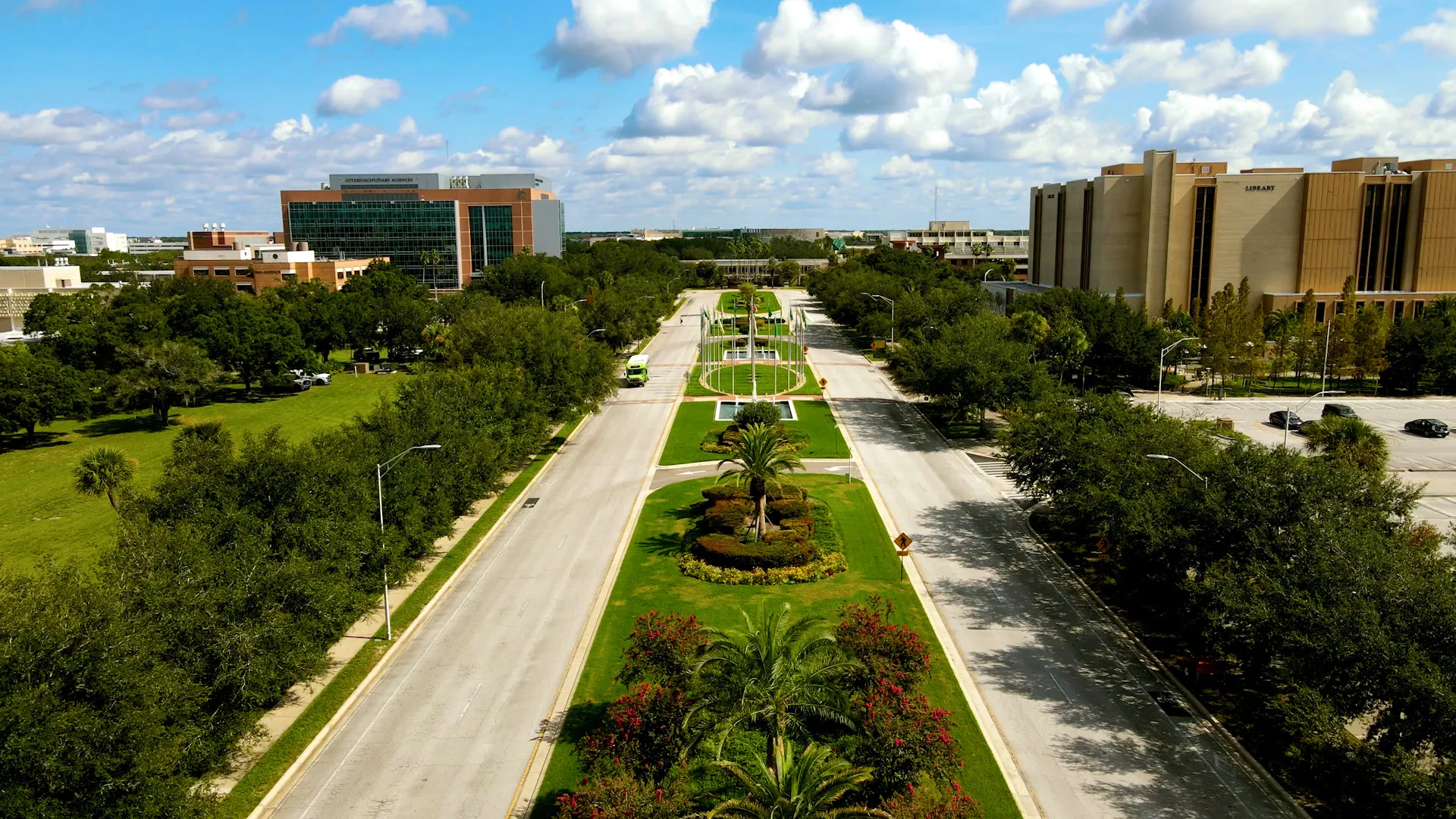 Aerial view along Leroy Collins Boulevard at USF's Tampa campus, with landscaped medians and the library